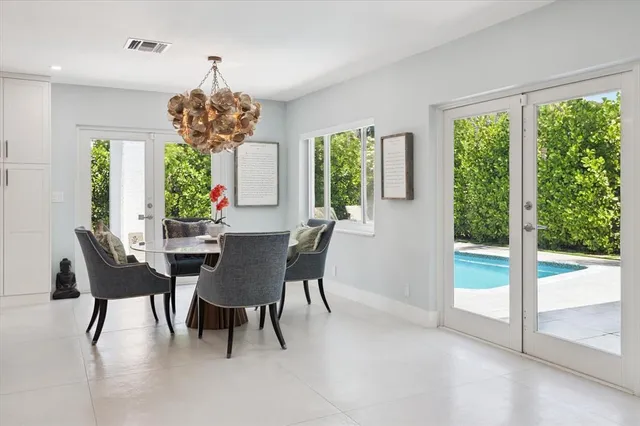 a dining room with furniture a chandelier and a large window