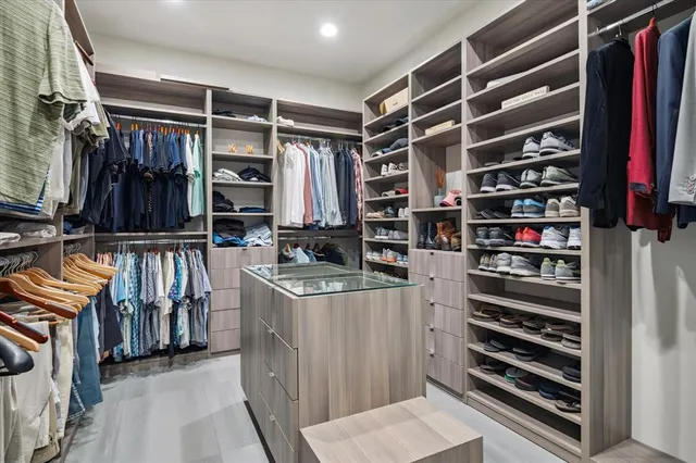 a view of walk in closet with clothes and shoes