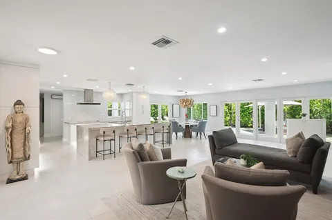 a dining room with furniture a large window and a view of kitchen
