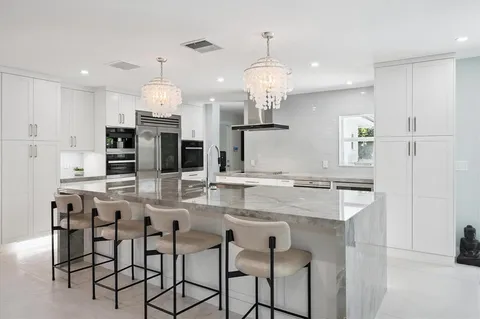 a kitchen with kitchen island granite countertop a table and chairs in it