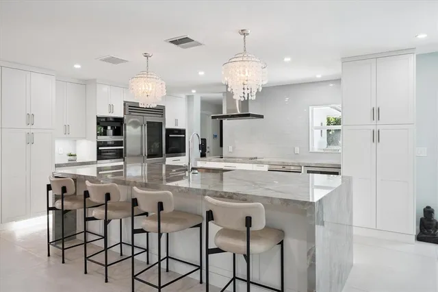a kitchen with kitchen island granite countertop a table and chairs in it