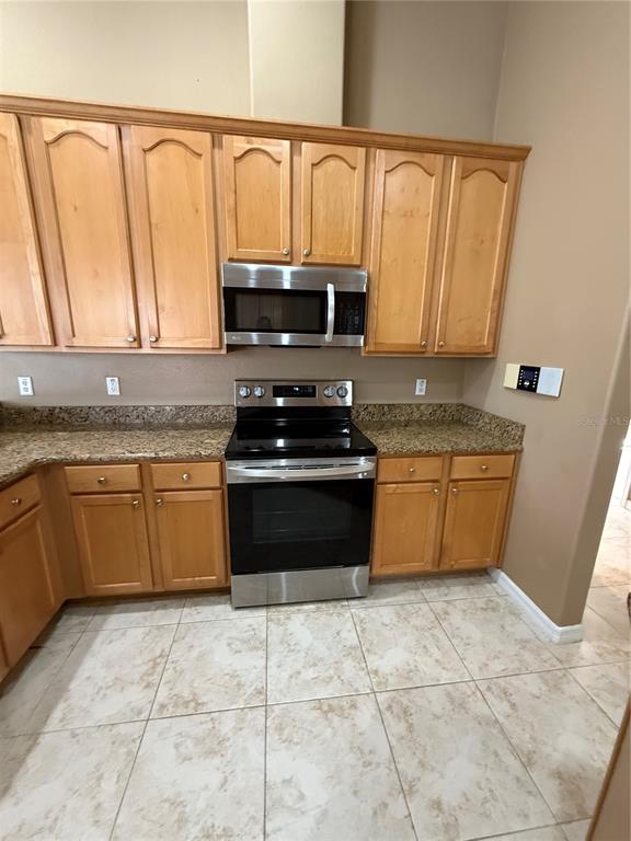 3231 Pawleys Loop North St. Cloud, FL 34769 - Photo 11 of 34 a kitchen with a stove a sink a microwave and cabinets