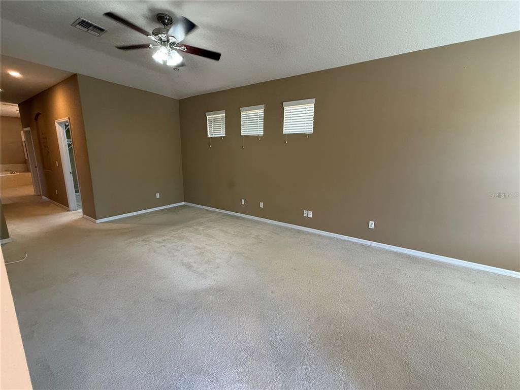 3231 Pawleys Loop North St. Cloud, FL 34769 - Photo 15 of 34 a view of an empty room with a ceiling fan