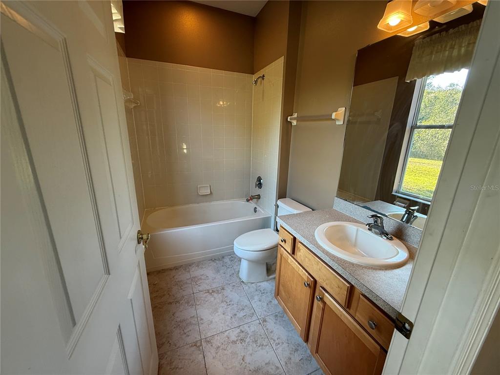 3231 Pawleys Loop North St. Cloud, FL 34769 - Photo 22 of 34 a bathroom with a sink a toilet and bathtub