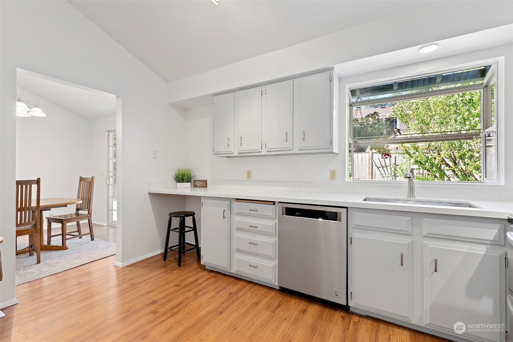 1229 206th Street Southeast Bothell, WA 98012 - Photo 10 of 40 a kitchen with white cabinets and wooden floors