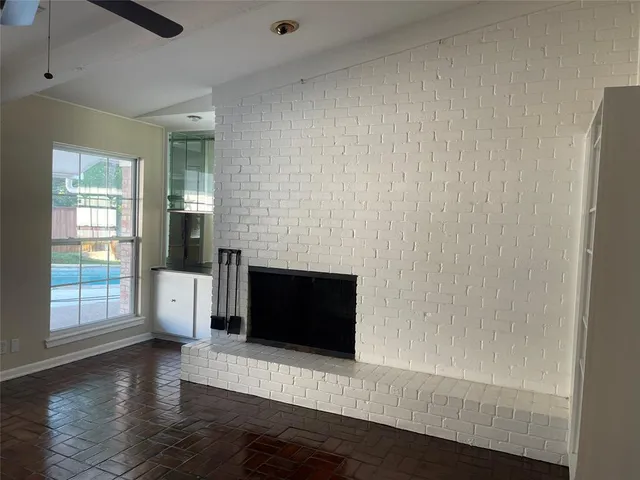 an empty room with wooden floor and fireplace