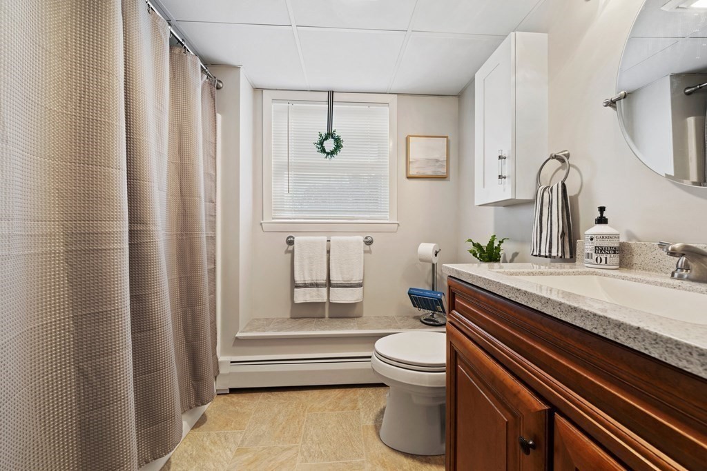 26-28 South Road Londonderry, NH 03053 - Photo 10 of 27 a bathroom with a granite countertop toilet sink and mirror