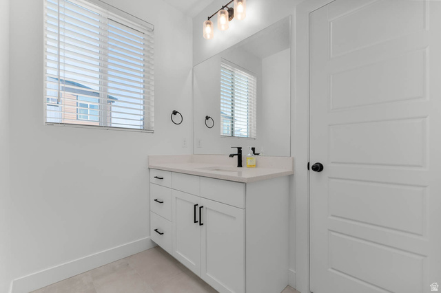8307 Durham Street Sandy, UT 84070 - Photo 10 of 29 Bathroom featuring a single-sink vanity with white cabinetry, light-toned countertop, and matte black hardware