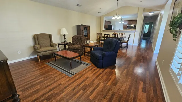 a living room with furniture and a wooden floor