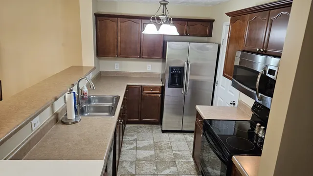 a kitchen with refrigerator and chairs