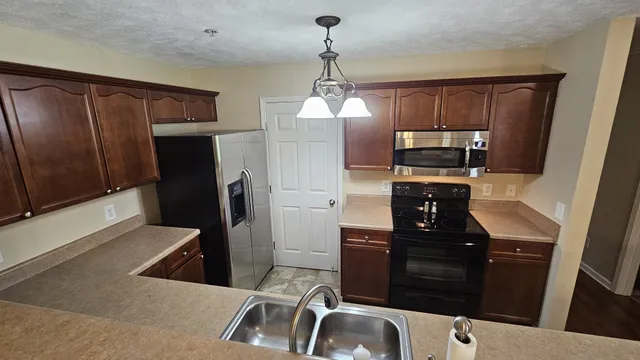 a kitchen with a refrigerator sink and wooden cabinets