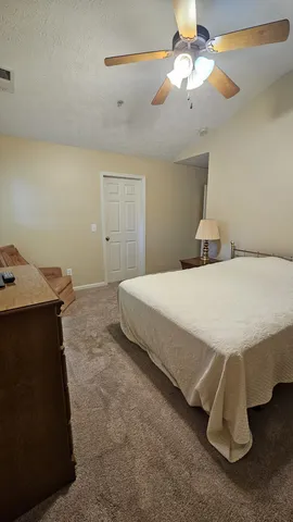 a spacious bedroom with a bed and a chandelier