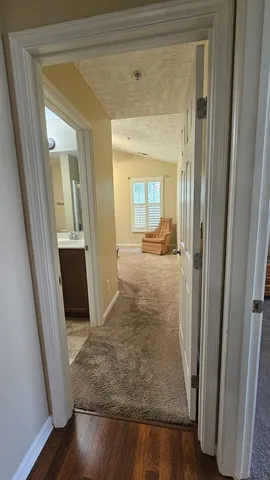 a view of a hallway view with wooden floor and living room