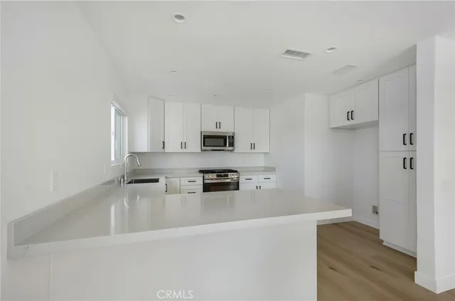 a kitchen with stainless steel appliances a refrigerator and a stove top oven