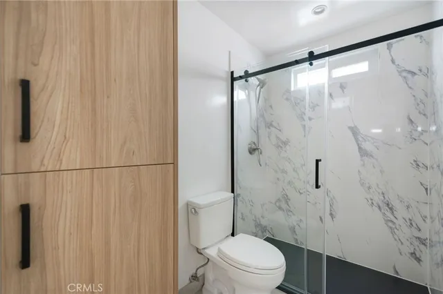 a bathroom with a shower toilet and sink