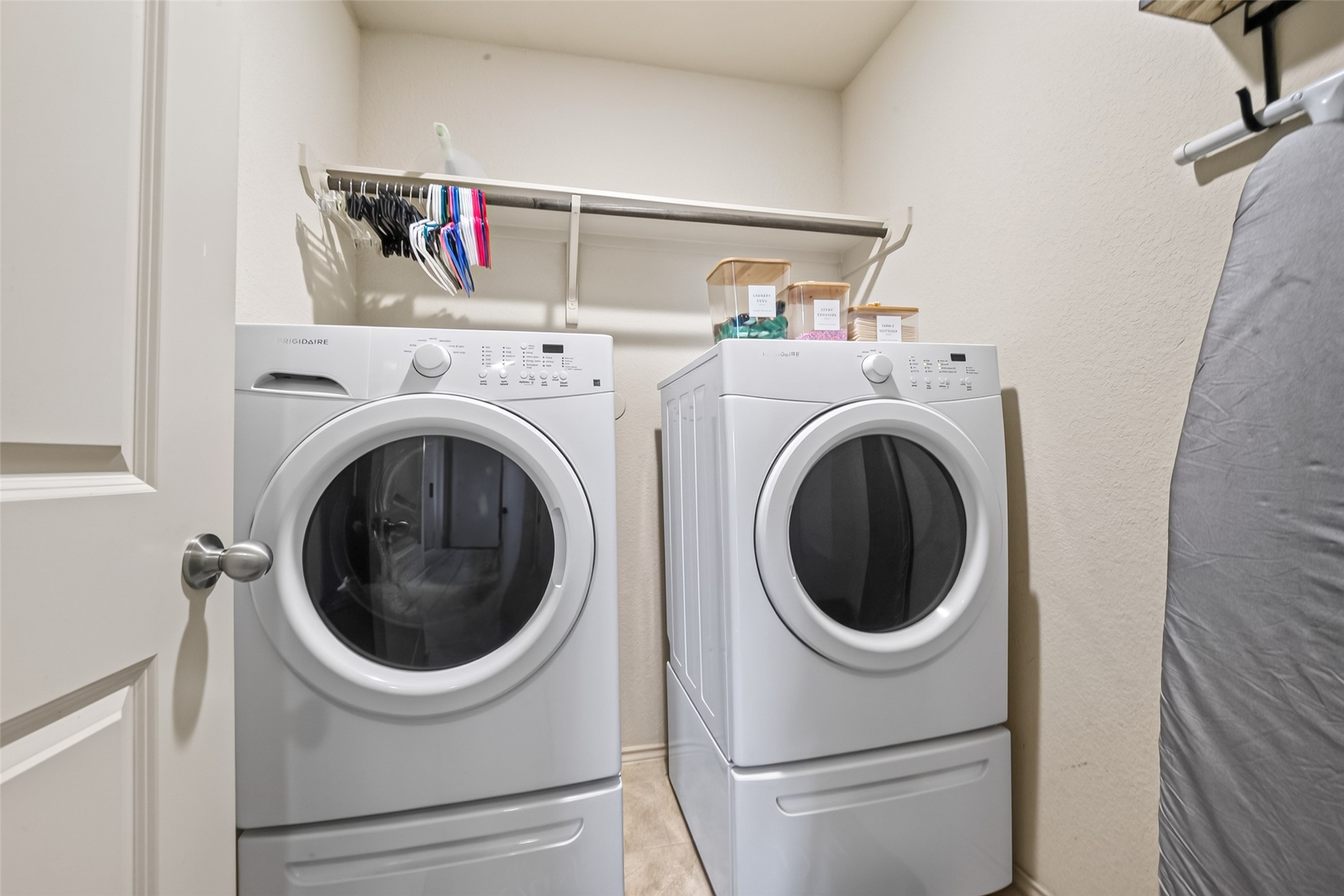 23202 Joy Ridge Drive Spring, TX 77373 - Photo 28 of 48 Convenient laundry room equipped with modern washer and dryer, featuring ample shelving and storage space.