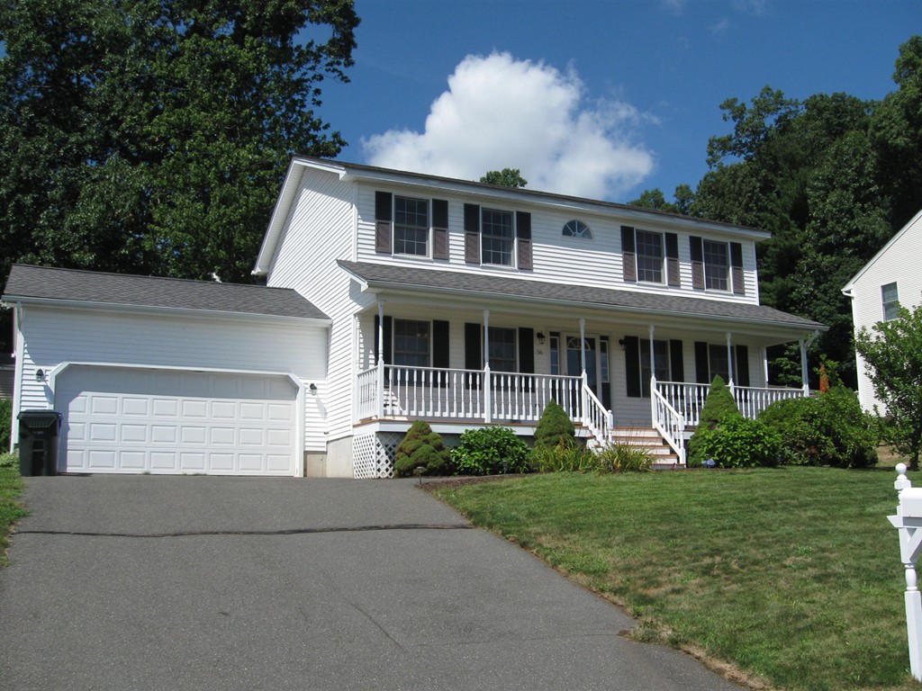 a front view of a house with a yard and potted plants