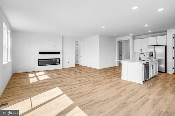 a room with a bed and a kitchen view