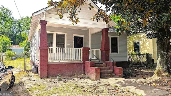 a view of a house with a small yard and wooden floor and fence