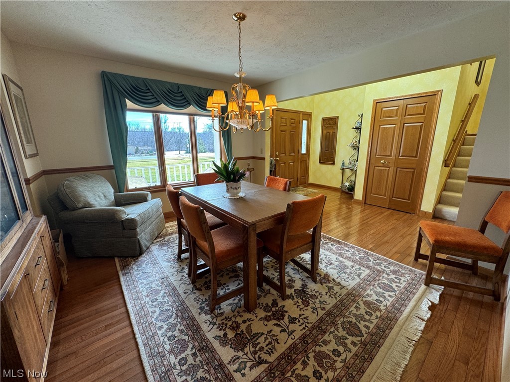 9615 Johnnycake Ridge Road Mentor, OH 44060 - Photo 16 of 35 Dining room featuring a chandelier, dark wood-type flooring, and large front windows