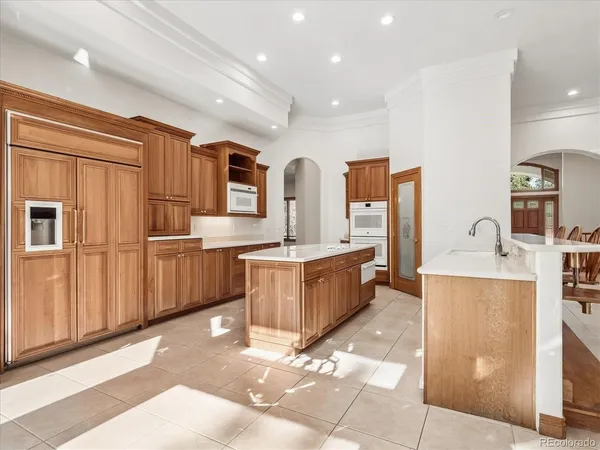 a large kitchen with kitchen island granite countertop a stove a sink and a microwave