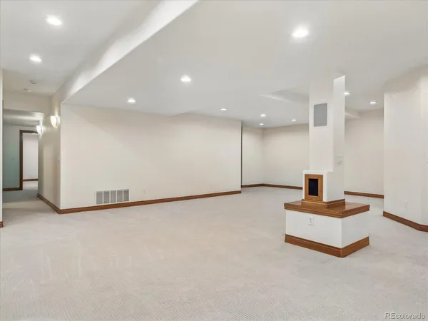 an empty room with windows and fireplace