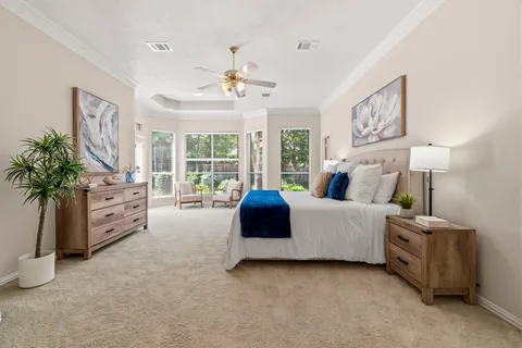 a bedroom with furniture and a large window