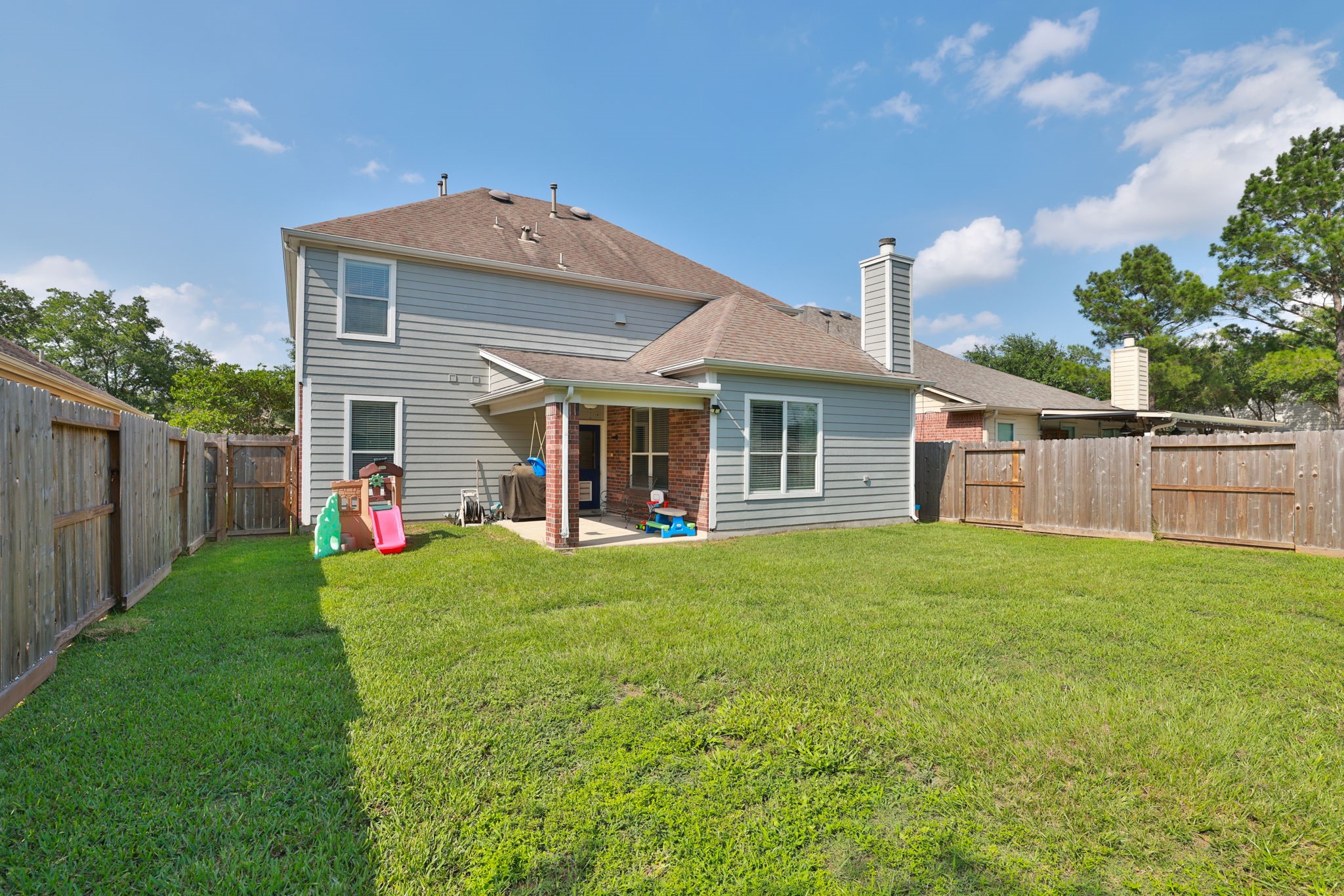 a front view of a house with a yard and trees