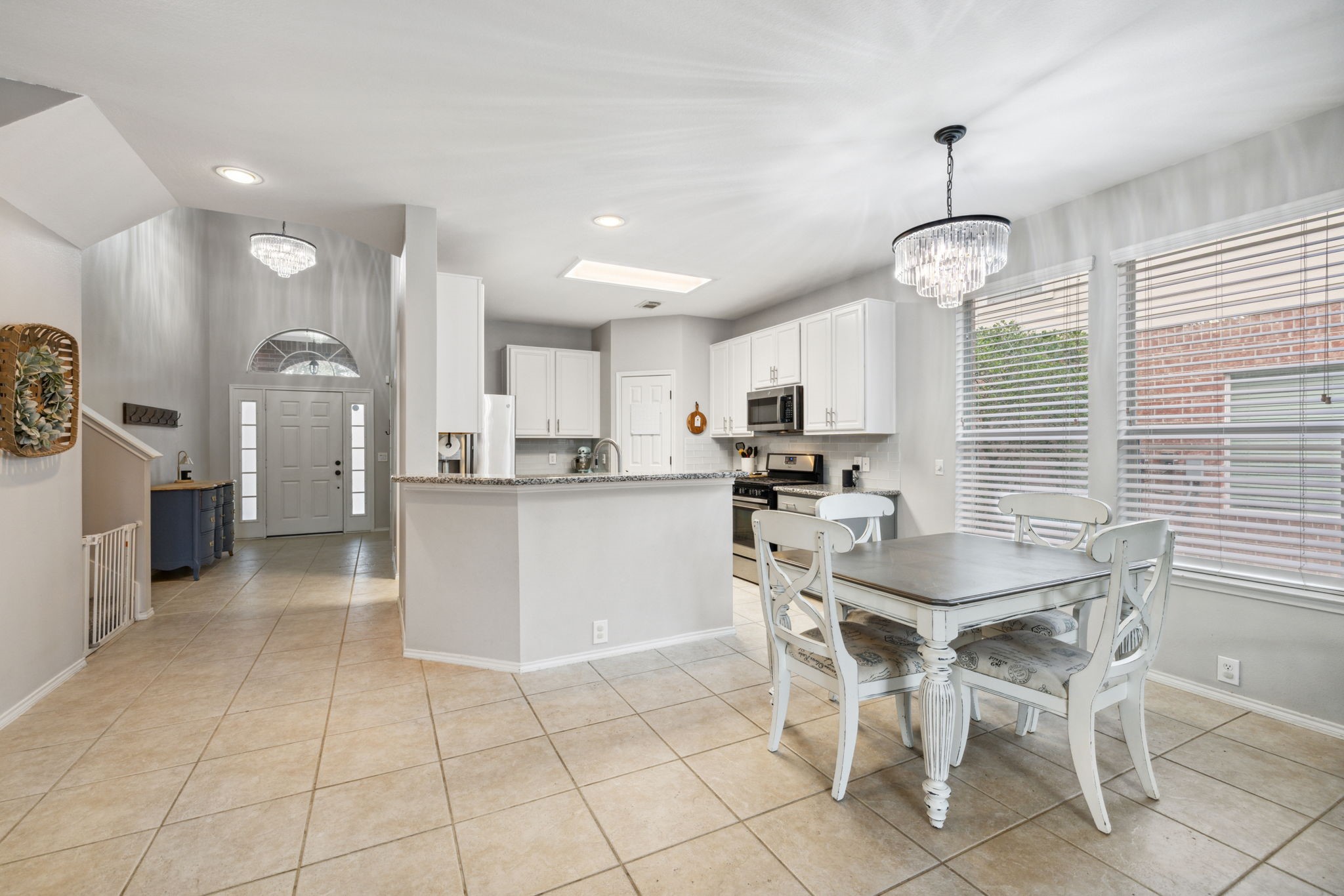 3526 Azalea Sands Drive Spring, TX 77386 - Photo 13 of 39 a kitchen with stainless steel appliances kitchen island granite countertop a refrigerator a stove a sink a table and chairs