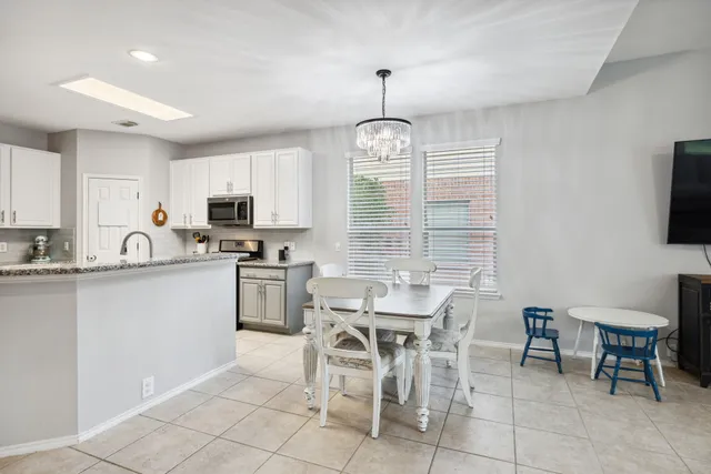 a kitchen with appliances cabinets and chair