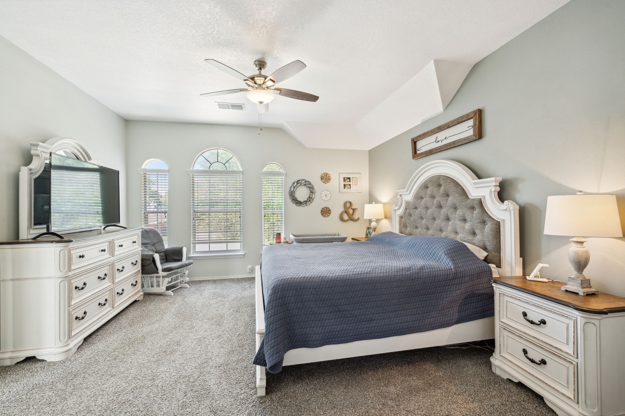 3526 Azalea Sands Drive Spring, TX 77386 - Photo 24 of 39 a bedroom with a bed a chandelier and a dresser