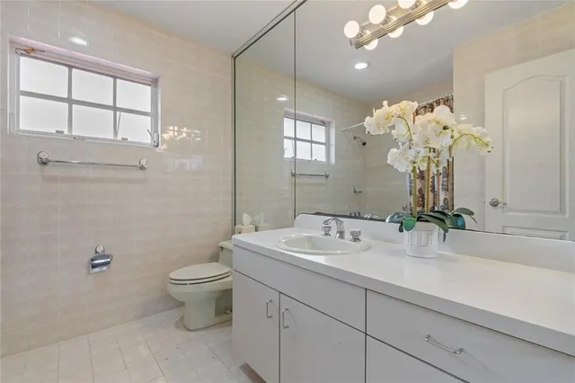 a bathroom with a sink a toilet and mirror