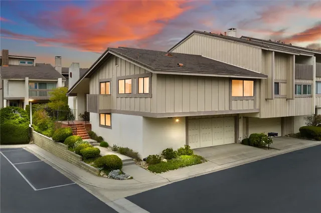 a front view of a house with a yard and potted plants