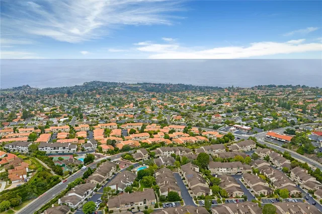 a view of a patio with table and chairs under an umbrella with palm trees