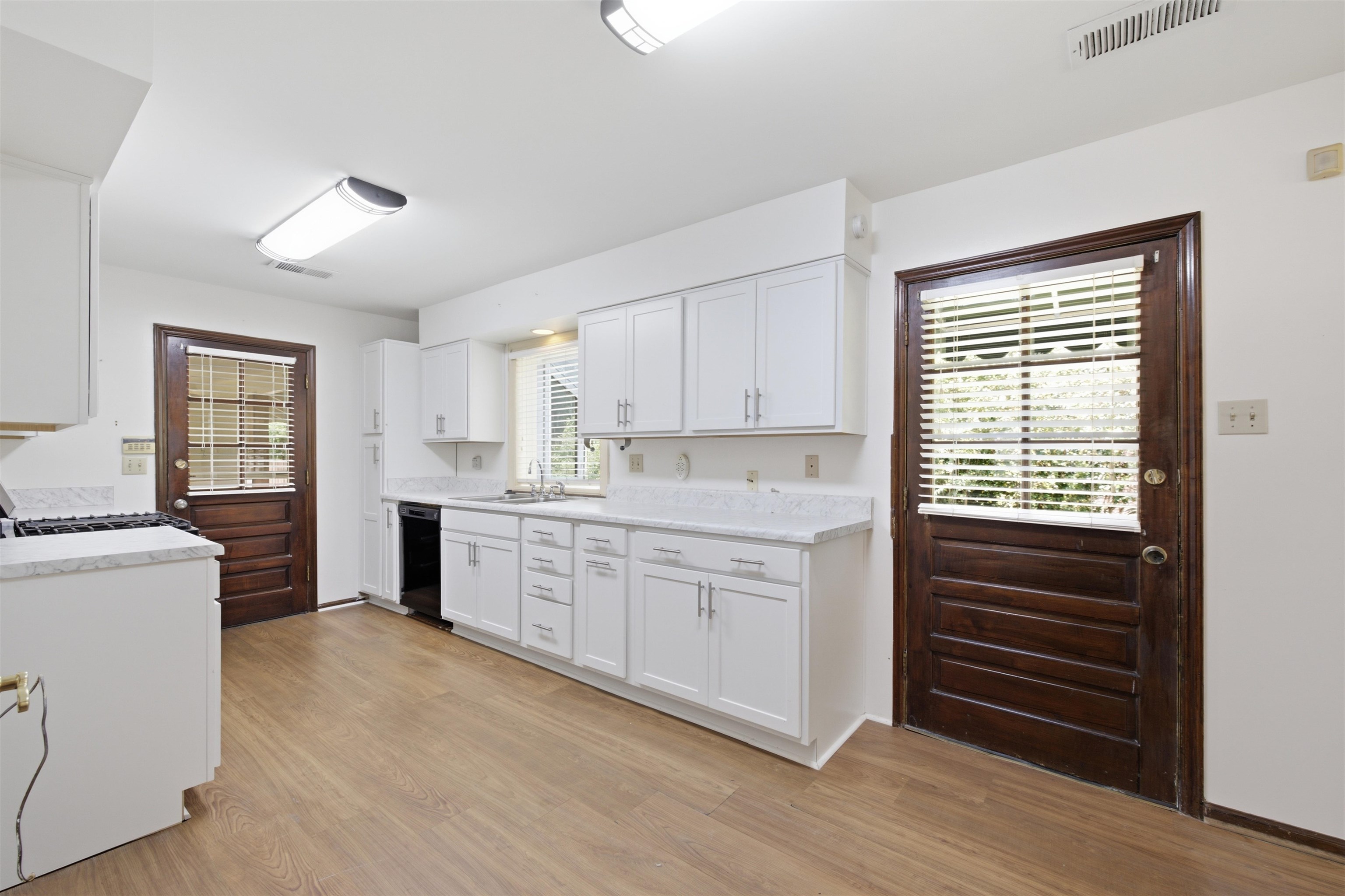 3007 Ruskin Road Bartlett, TN 38134 - Photo 6 of 37 Kitchen featuring white cabinetry, light-toned countertops, wood-finish flooring, two paneled wood doors with window inserts, and recessed lighting