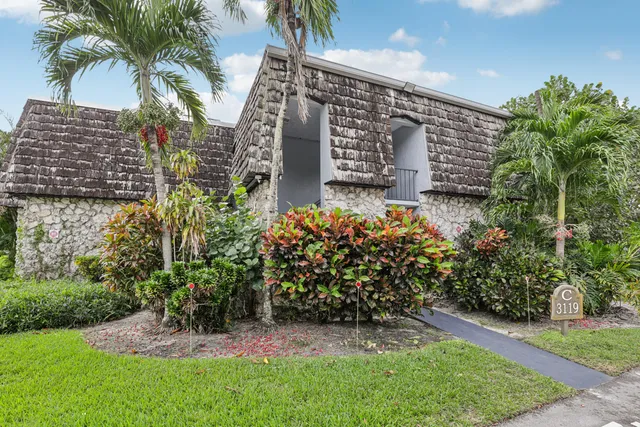 a front view of a house with a yard and potted plants