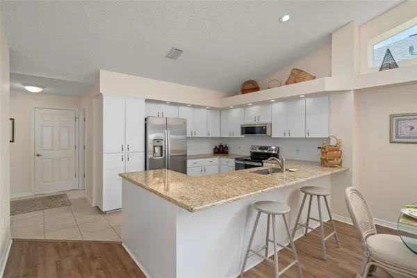 a kitchen with stainless steel appliances granite countertop a sink refrigerator and cabinets