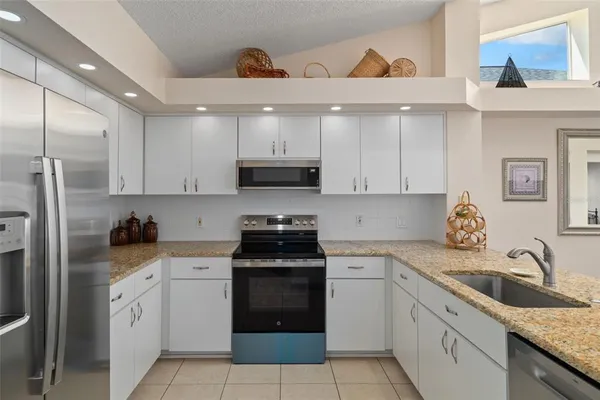 a kitchen with white cabinets stainless steel appliances and sink