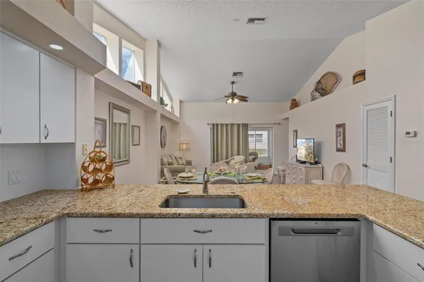 a kitchen with granite countertop a sink and cabinets