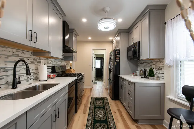 a kitchen with stainless steel appliances a sink stove and refrigerator