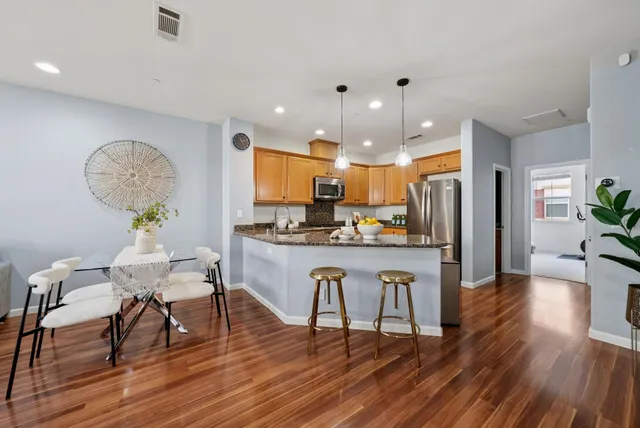 a kitchen with stainless steel appliances granite countertop a sink stove and refrigerator
