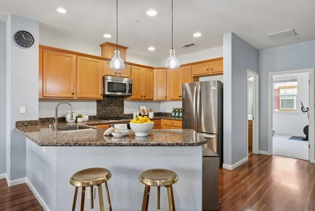 a kitchen with stainless steel appliances granite countertop a sink stove and microwave