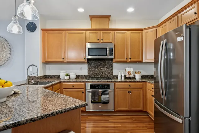 a kitchen with granite countertop a sink a stove and cabinets