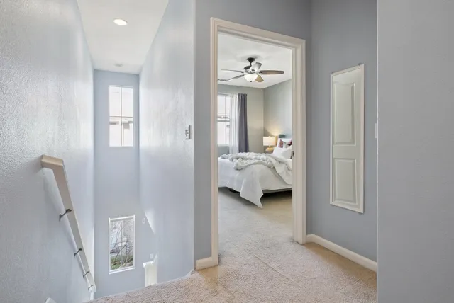 a bedroom with a bed potted plant on dresser and a window