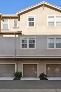 a view of a white building among the street and tall buildings