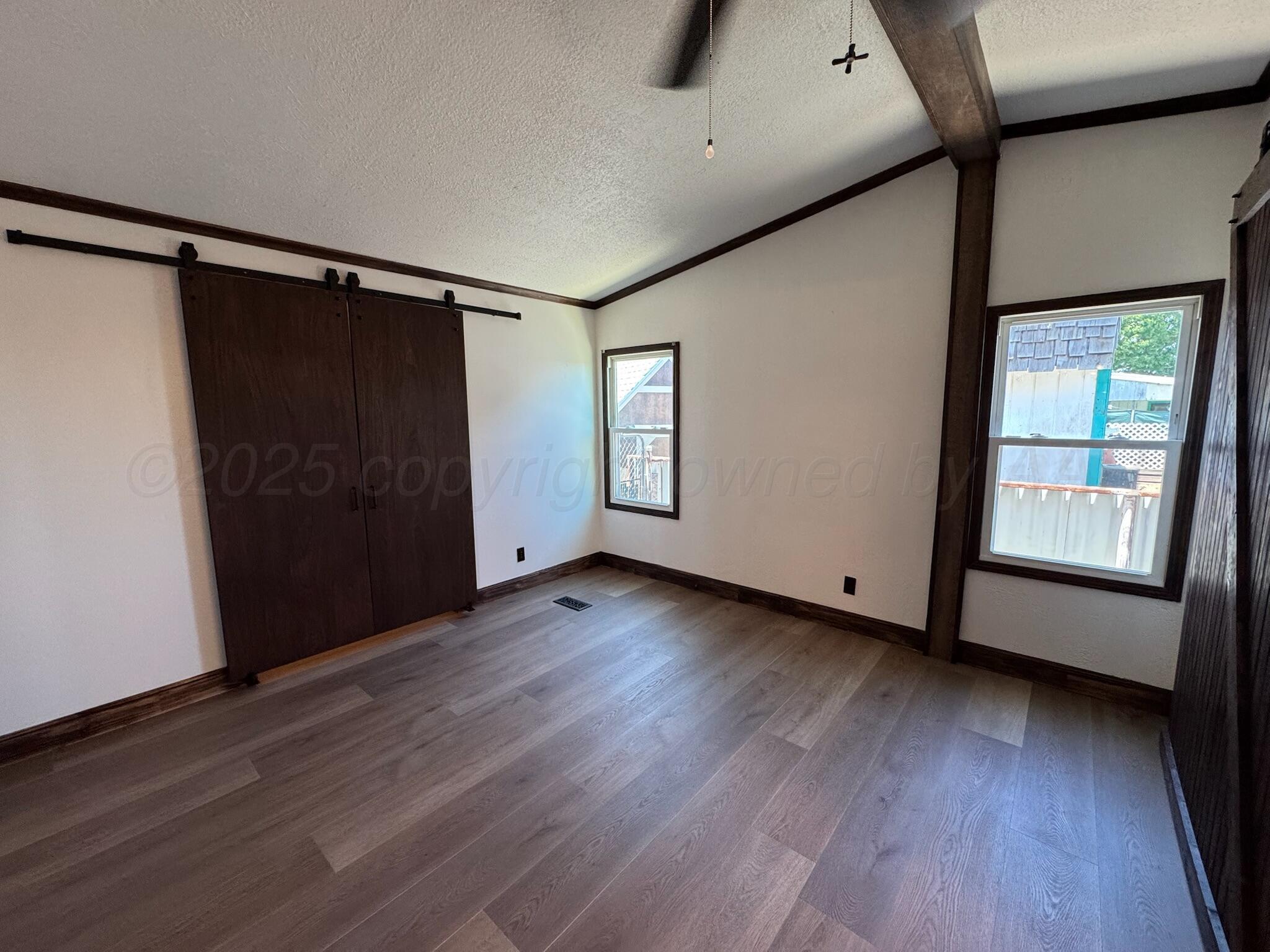 403 Aaron Road Fritch, TX 79036 - Photo 14 of 31 a view of an empty room with wooden floor and a window