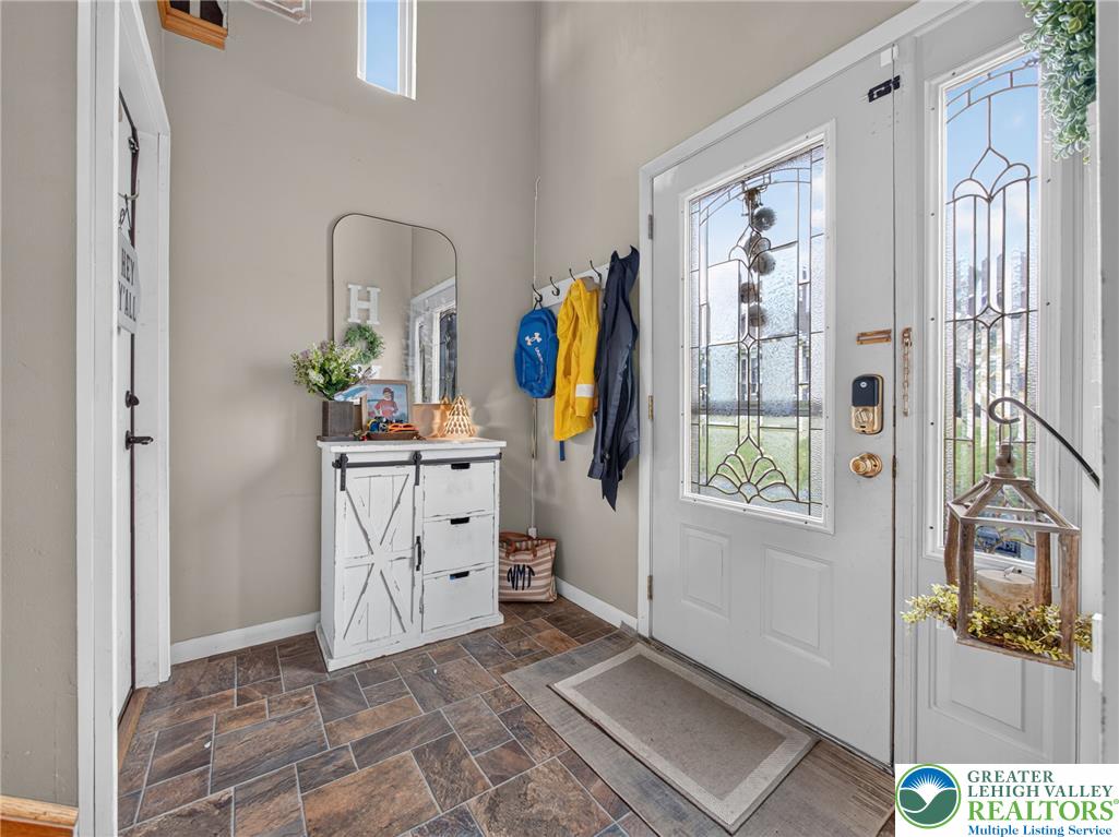 2628 Levans Road Coplay, PA 18037 - Photo 7 of 54 A welcoming entry offers durable tile flooring and a decorative leaded glass door with a transom window above.