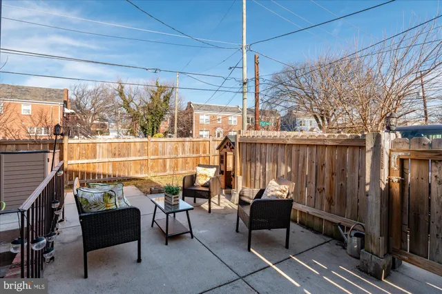 a couple of chairs sitting in patio with wooden fence