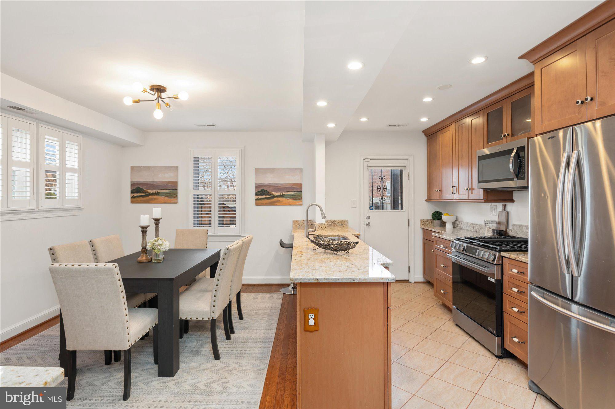 5049 North Capitol Street Northeast Washington, DC 20011 - Photo 6 of 20 a kitchen with refrigerator a sink dishwasher a dining table and chairs with wooden floor