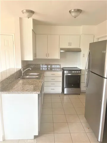 a kitchen with stainless steel appliances granite countertop a stove a sink and a refrigerator